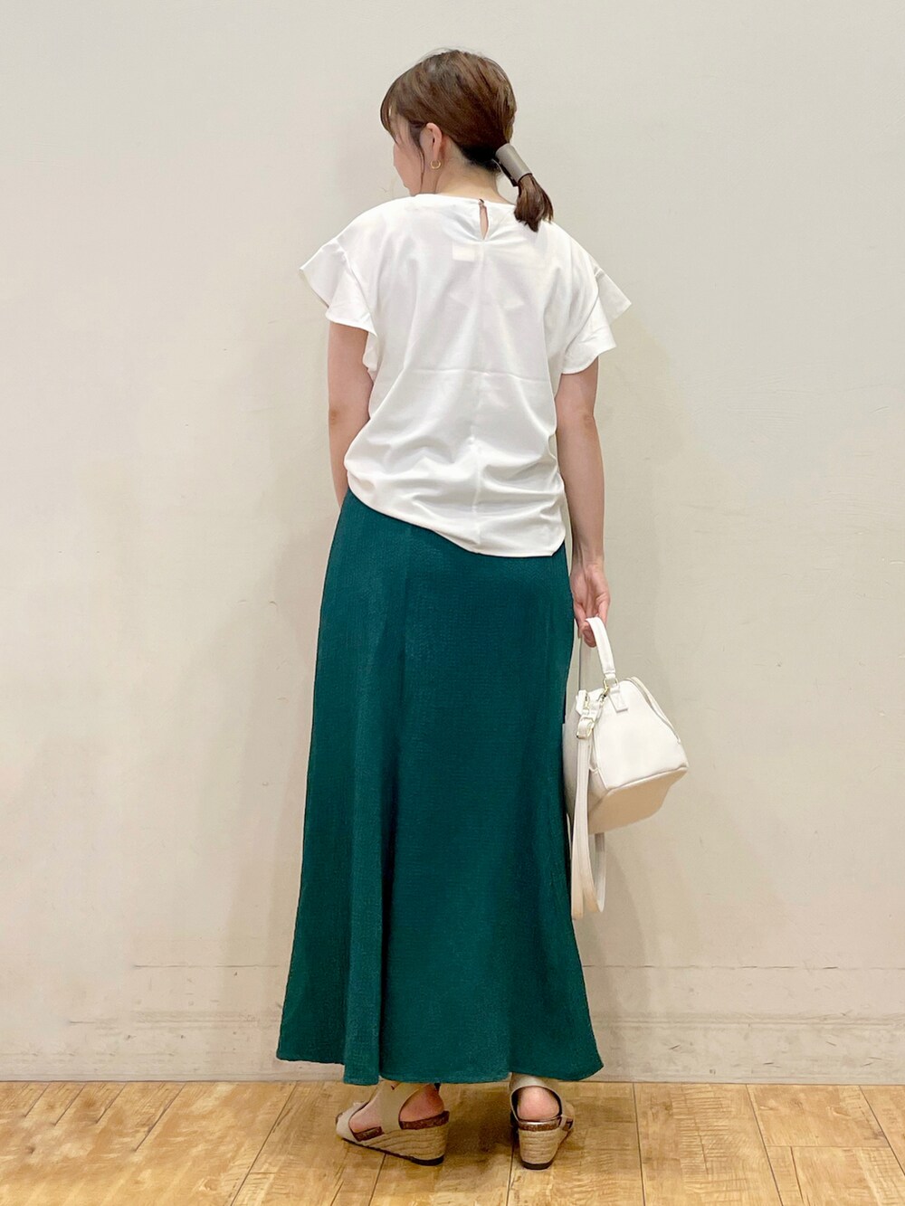 ホワイト系のTシャツ/カットソー、グリーン系のスカート、ホワイト系のショルダーバッグを着用したレディースの夏コーディネートの3枚目の写真