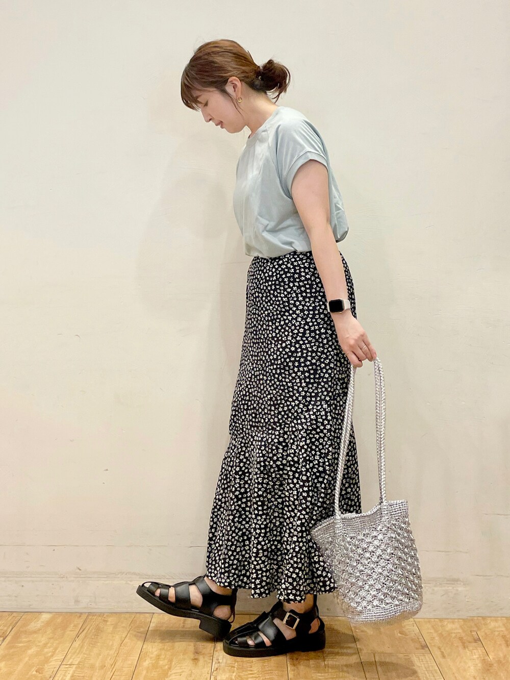 グリーン系のTシャツ/カットソー、ブラック系のスカート、シルバー系のトートバッグを着用したレディースの夏コーディネートの2枚目の写真