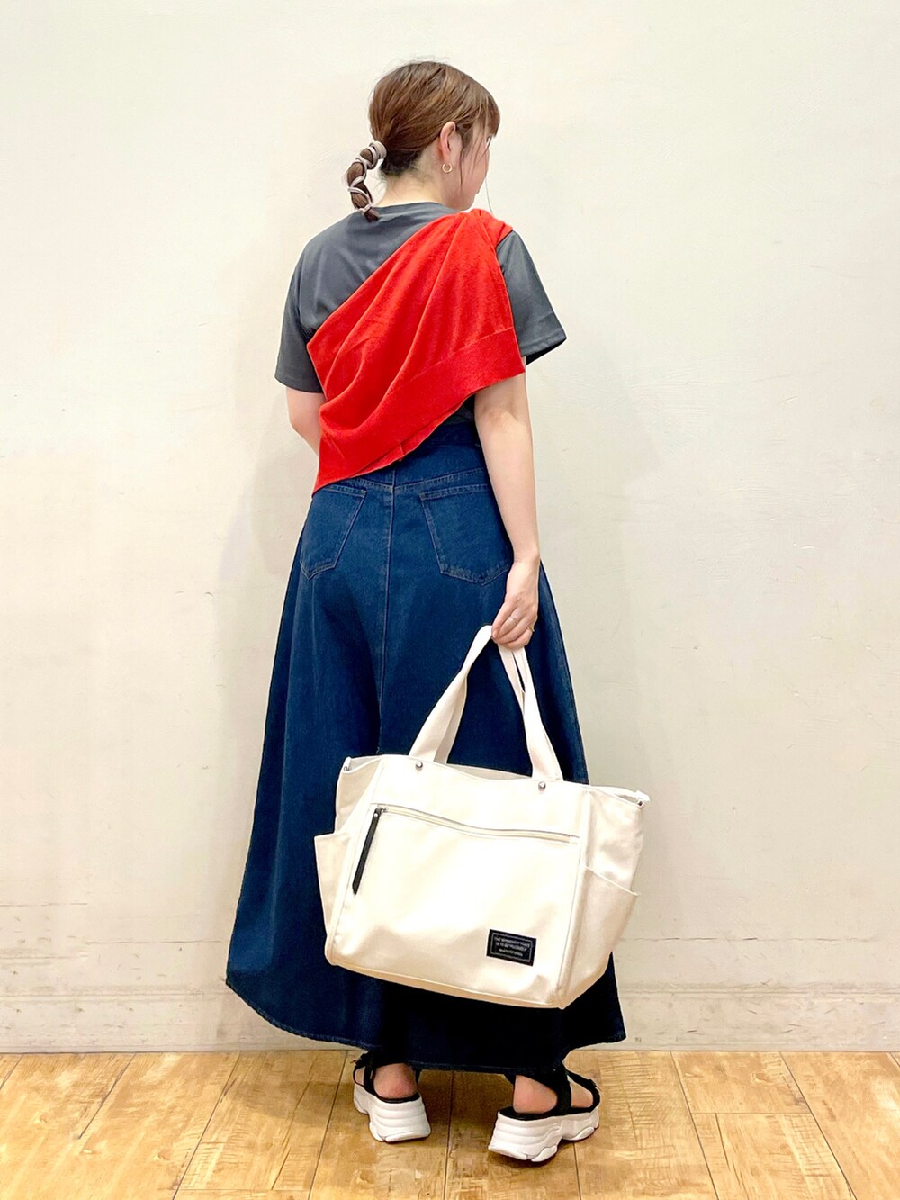 グレー系のTシャツ/カットソー、オレンジ系のカーディガン/ボレロ、ブルー系のスカートを着用したレディースの夏コーディネートの3枚目の写真