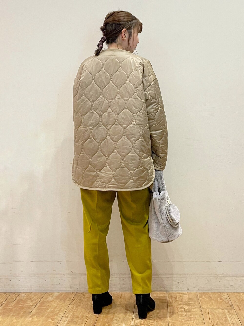 ベージュ系のその他アウター、ブラック系のニット/セーター、イエロー系のその他パンツを着用したレディースの冬コーディネートの2枚目の写真