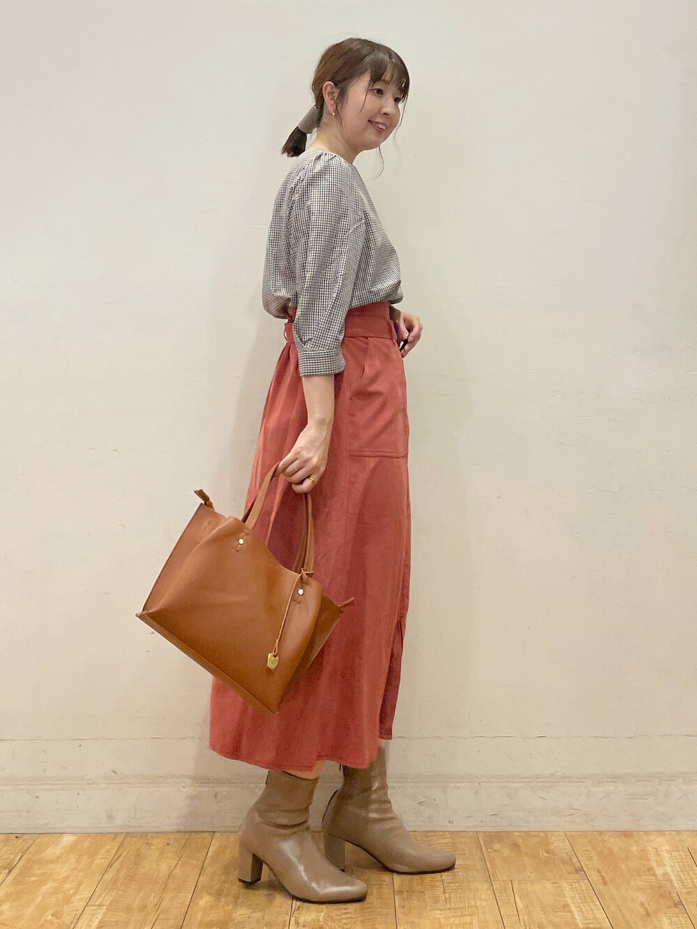 ベージュ系のシャツ/ブラウス、レッド系のスカート、イエロー系のトートバッグを着用したレディースの秋コーディネートの2枚目の写真