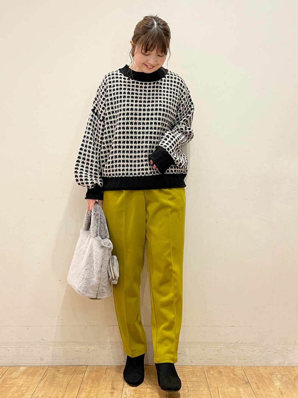 ベージュ系のその他アウター、ブラック系のニット/セーター、イエロー系のその他パンツを着用したレディースの冬コーディネートの3枚目の写真