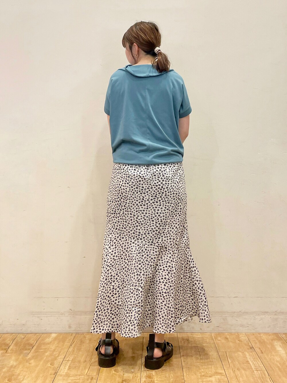 ブルー系のTシャツ/カットソー、ホワイト系のスカート、グレー系のトートバッグを着用したレディースの夏コーディネートの3枚目の写真