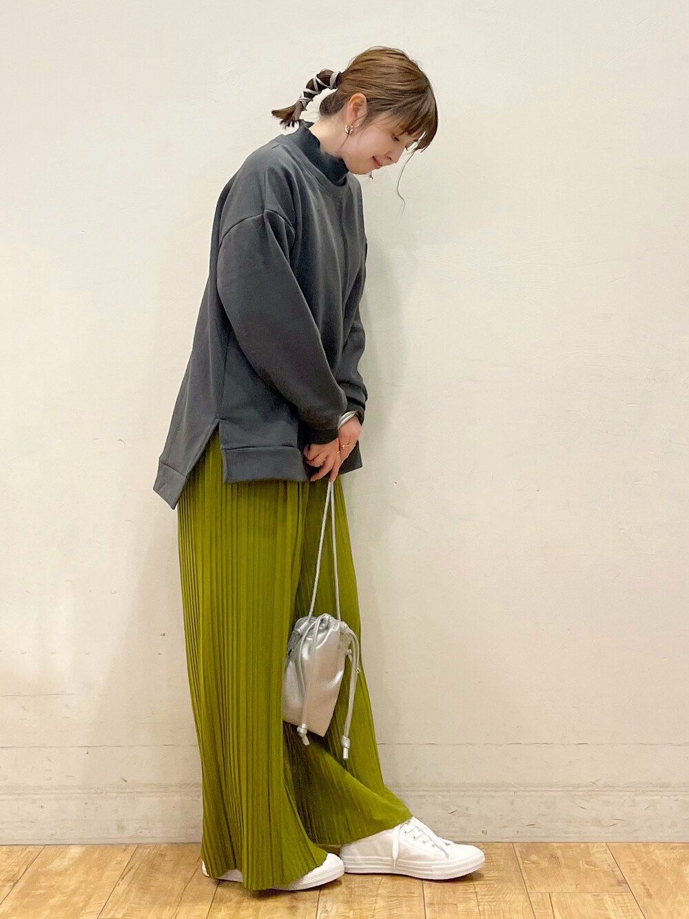 グレー系のスウェット、グリーン系のその他パンツ、シルバー系のショルダーバッグを着用したレディースの冬コーディネートの2枚目の写真