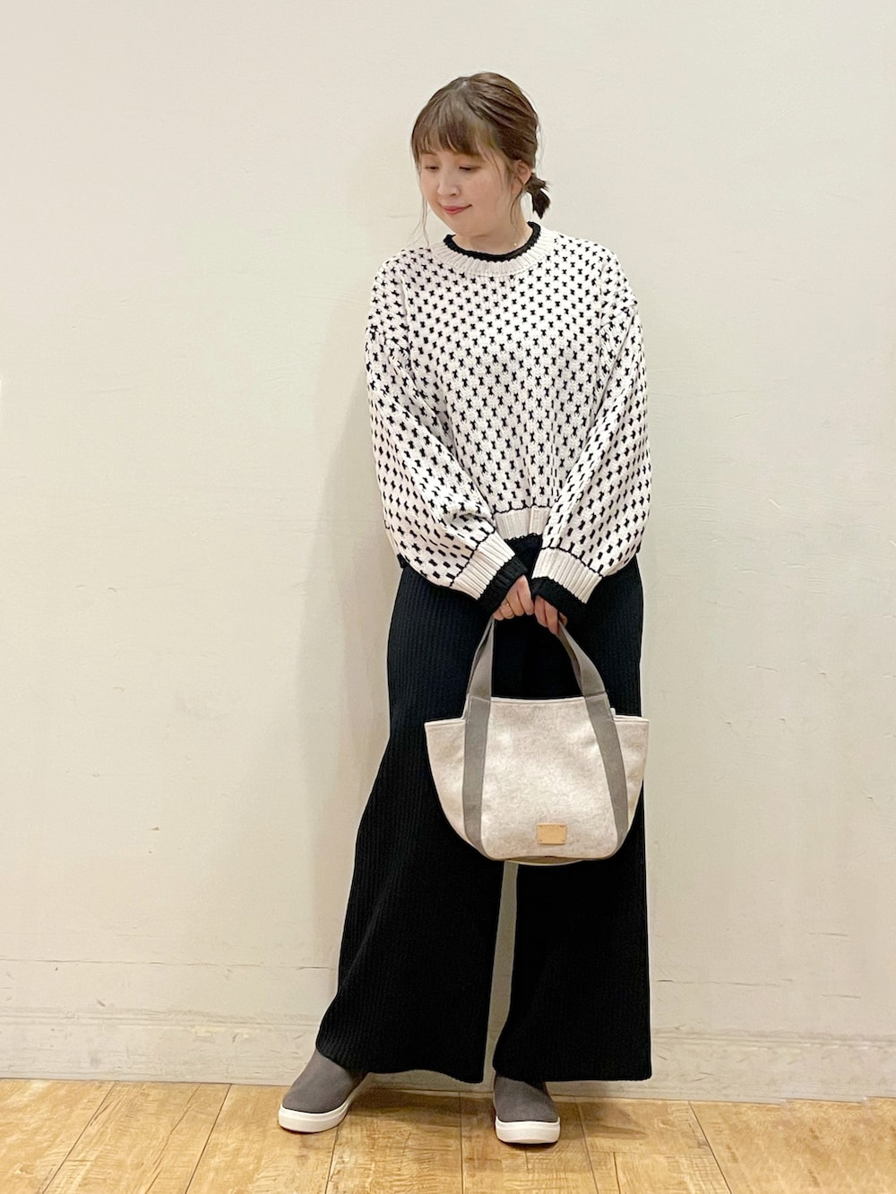 ベージュ系のニット/セーター、ブラック系のその他パンツ、ベージュ系のトートバッグを着用したレディースの秋コーディネートの3枚目の写真