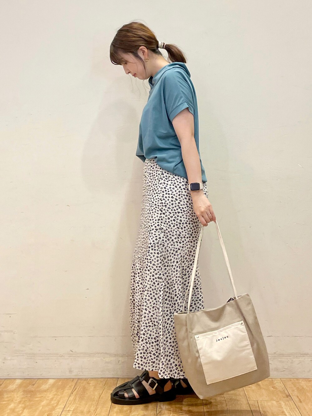 ブルー系のTシャツ/カットソー、ホワイト系のスカート、グレー系のトートバッグを着用したレディースの夏コーディネートの2枚目の写真