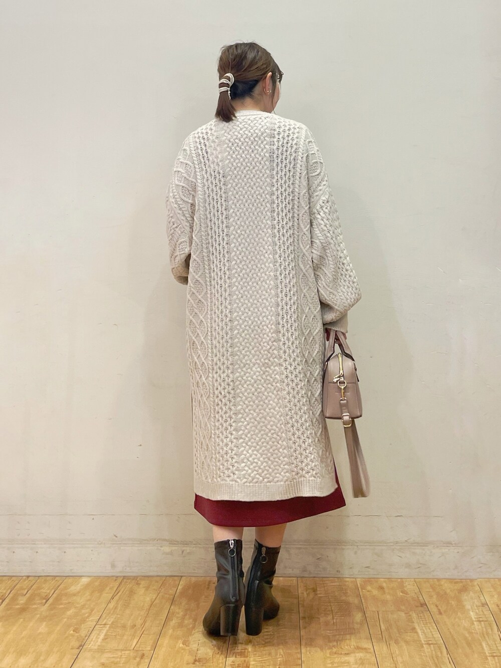 ベージュ系のカーディガン/ボレロ、レッド系のワンピース、グレー系のショルダーバッグを着用したレディースの秋コーディネートの3枚目の写真