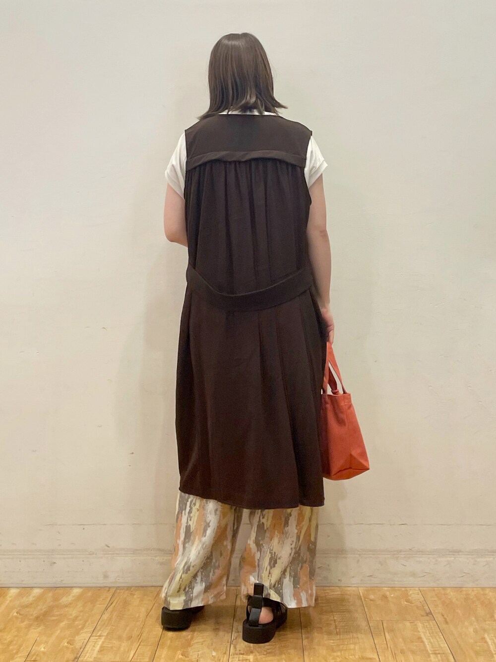 ベージュ系のTシャツ/カットソー、ブラウン系のベスト、レッド系のその他パンツを着用したレディースの夏コーディネートの4枚目の写真