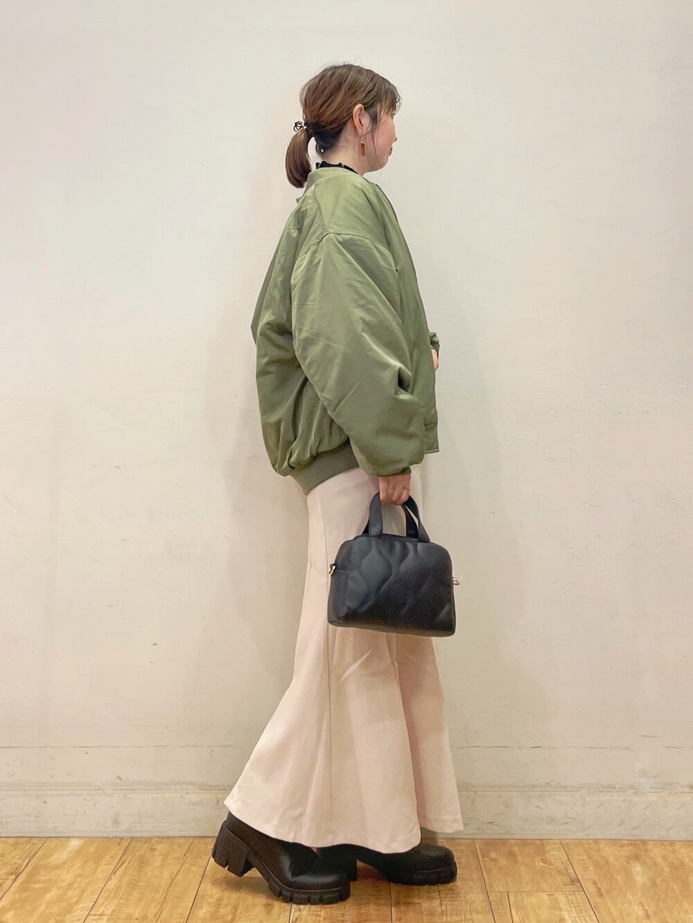 ブラック系のTシャツ/カットソー、ホワイト系のスカート、ブラック系のショルダーバッグを着用したレディースの秋コーディネートの2枚目の写真