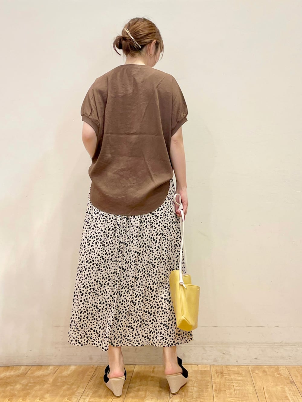 ブラウン系のシャツ/ブラウス、ホワイト系のスカート、イエロー系のショルダーバッグを着用したレディースの夏コーディネートの3枚目の写真