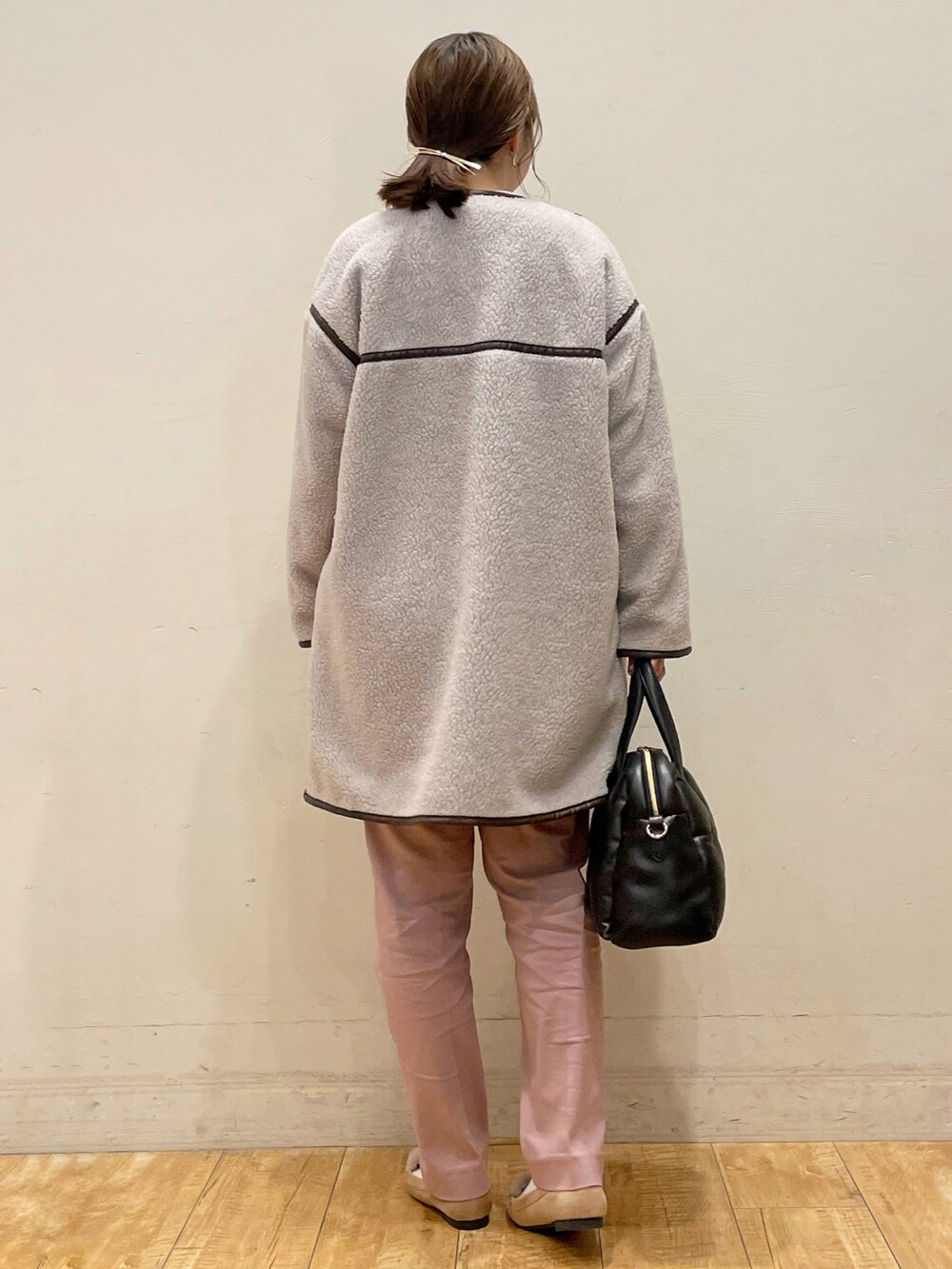 グレー系のノーカラーコート、ホワイト系のニット/セーター、ピンク系のその他パンツを着用したレディースの冬コーディネートの3枚目の写真