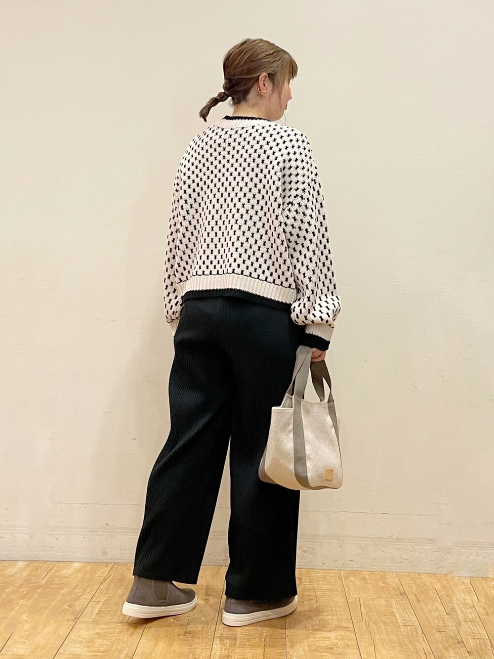 ベージュ系のニット/セーター、ブラック系のその他パンツ、ベージュ系のトートバッグを着用したレディースの秋コーディネートの2枚目の写真