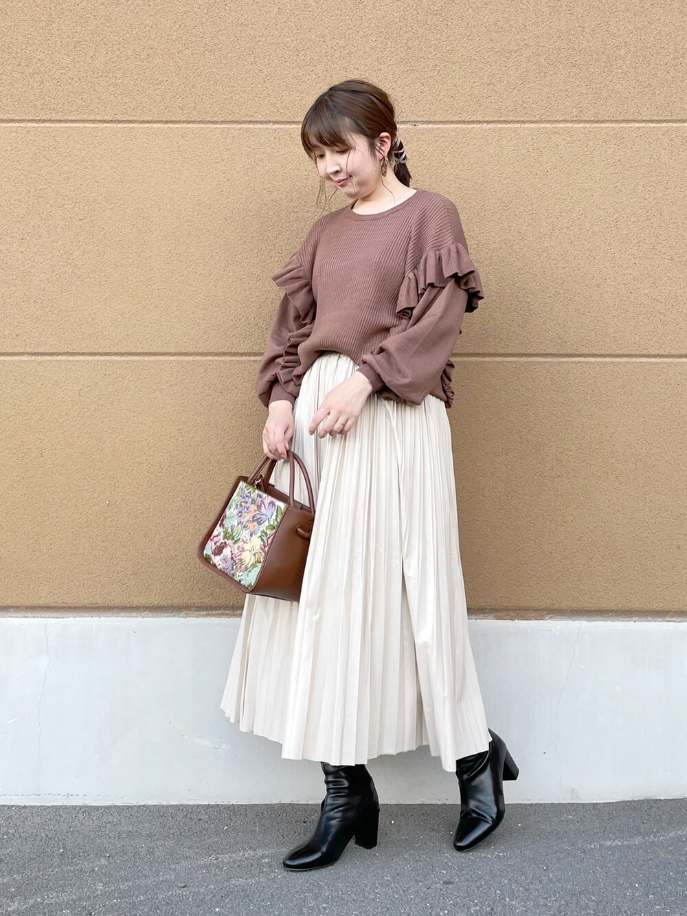 ブラウン系のニット/セーター、ベージュ系のスカート、ベージュ系のトートバッグを着用したレディースの秋コーディネートの2枚目の写真
