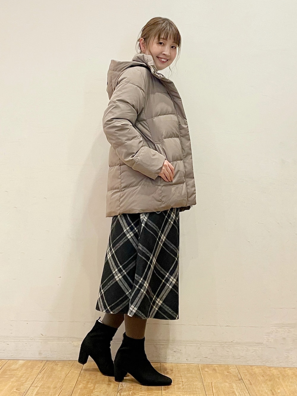 ベージュ系のダウンジャケット/コート、ブルー系のニット/セーター、ブラック系のスカートを着用したレディースの冬コーディネートの2枚目の写真