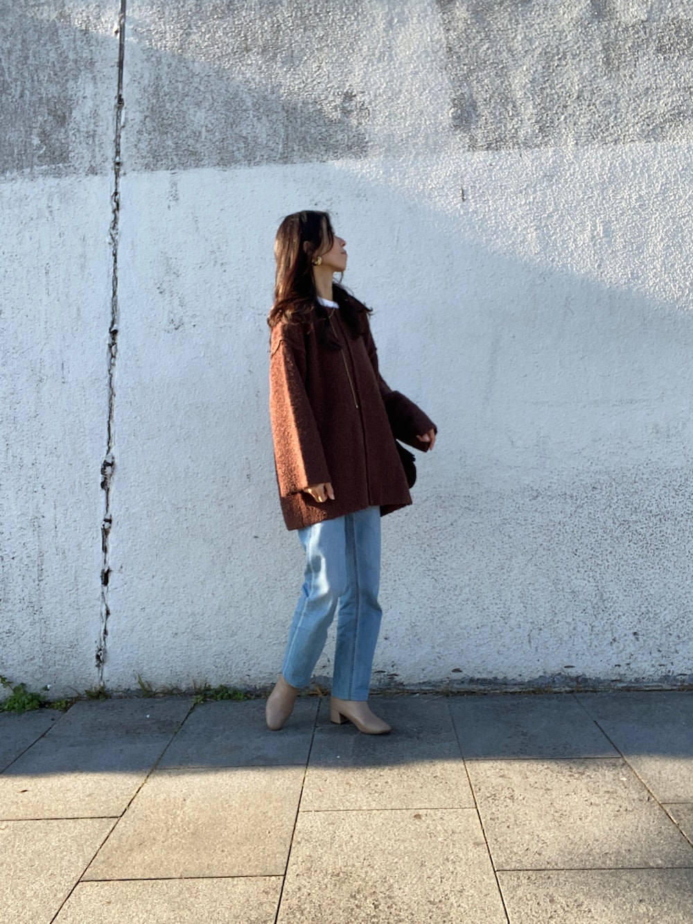 ブラウン系のニット/セーター、ブルー系のデニムパンツ、ベージュ系のブーツを着用したレディースの冬コーディネートの2枚目の写真