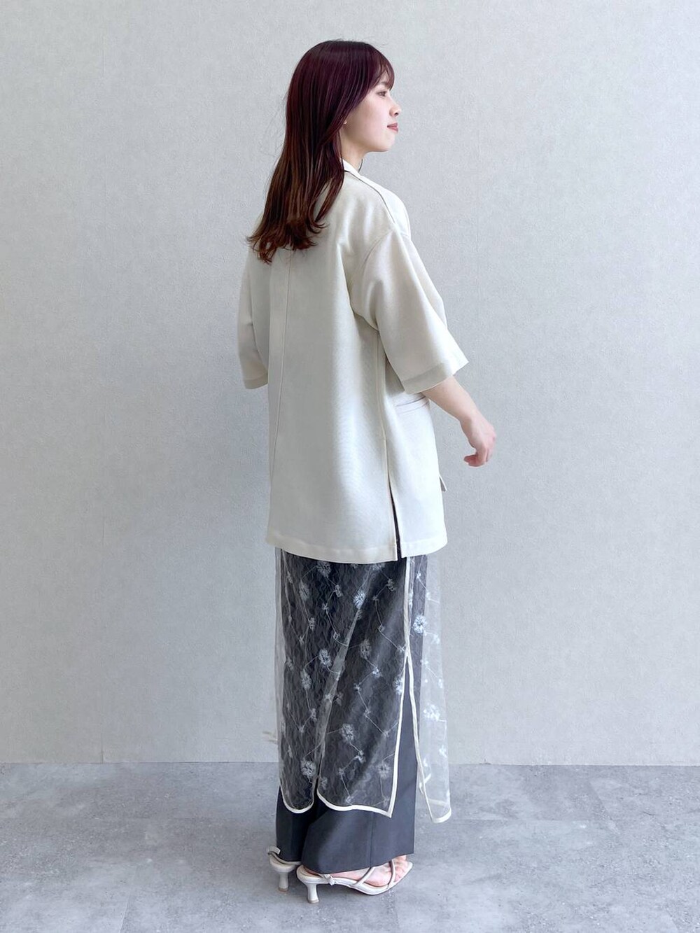 ホワイト系のサンダル、ベージュ系のキャミソール、ホワイト系のテーラードジャケットを着用したレディースの春コーディネートの4枚目の写真