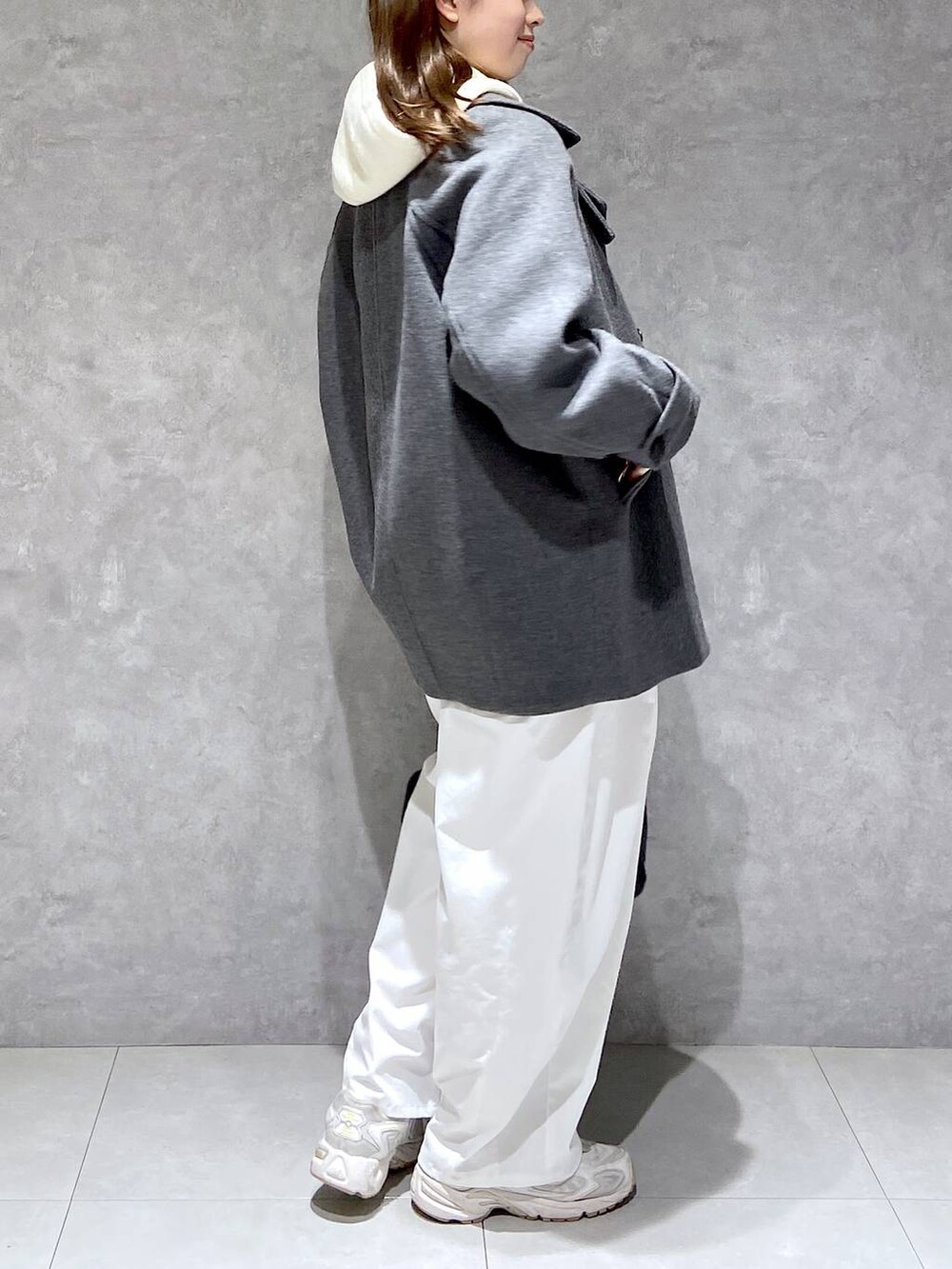 グレー系のピーコート、ホワイト系のその他パンツ、ブラック系のボストンバッグを着用したレディースの秋コーディネートの4枚目の写真