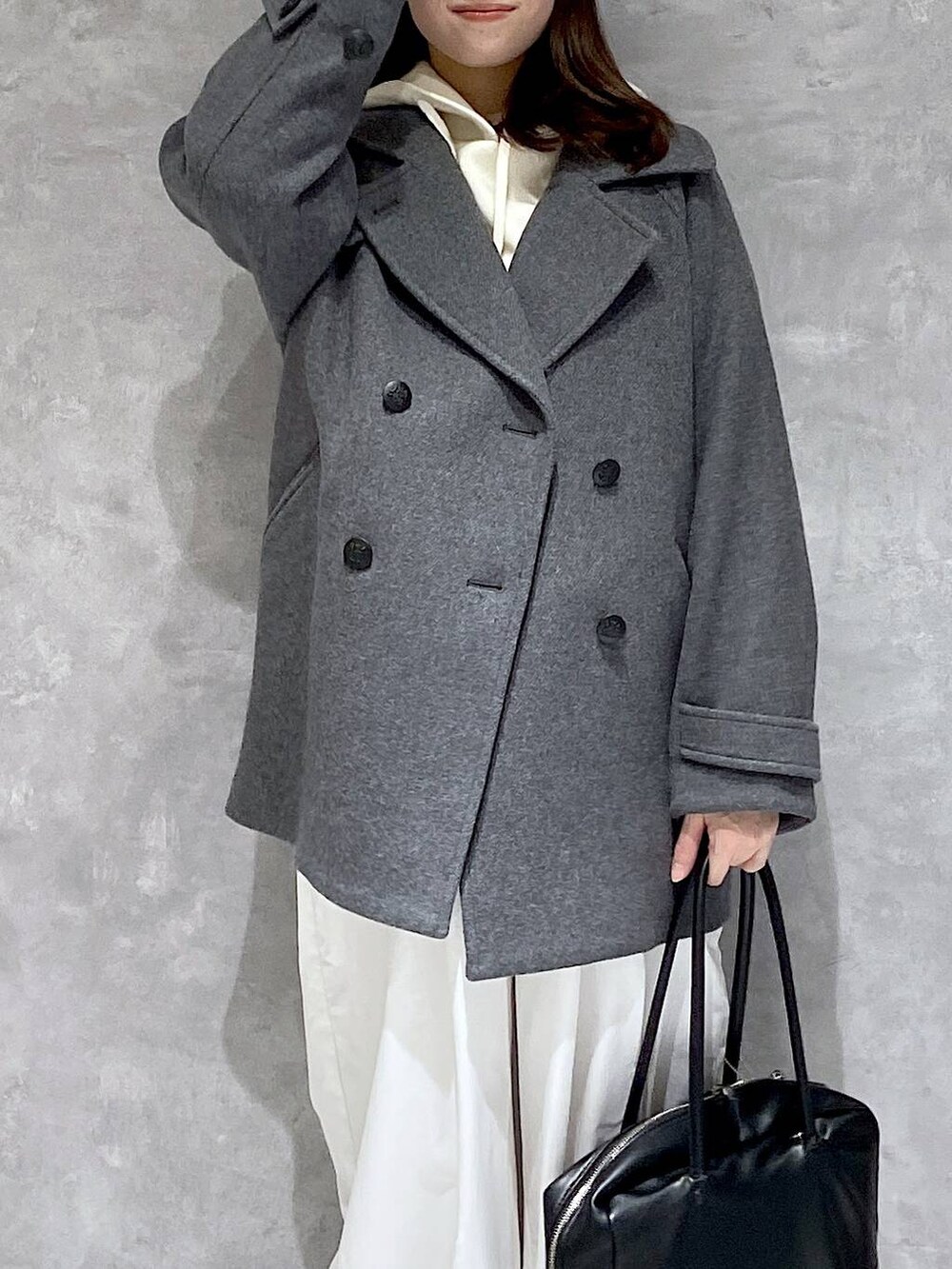 グレー系のピーコート、ホワイト系のその他パンツ、ブラック系のボストンバッグを着用したレディースの秋コーディネートの3枚目の写真