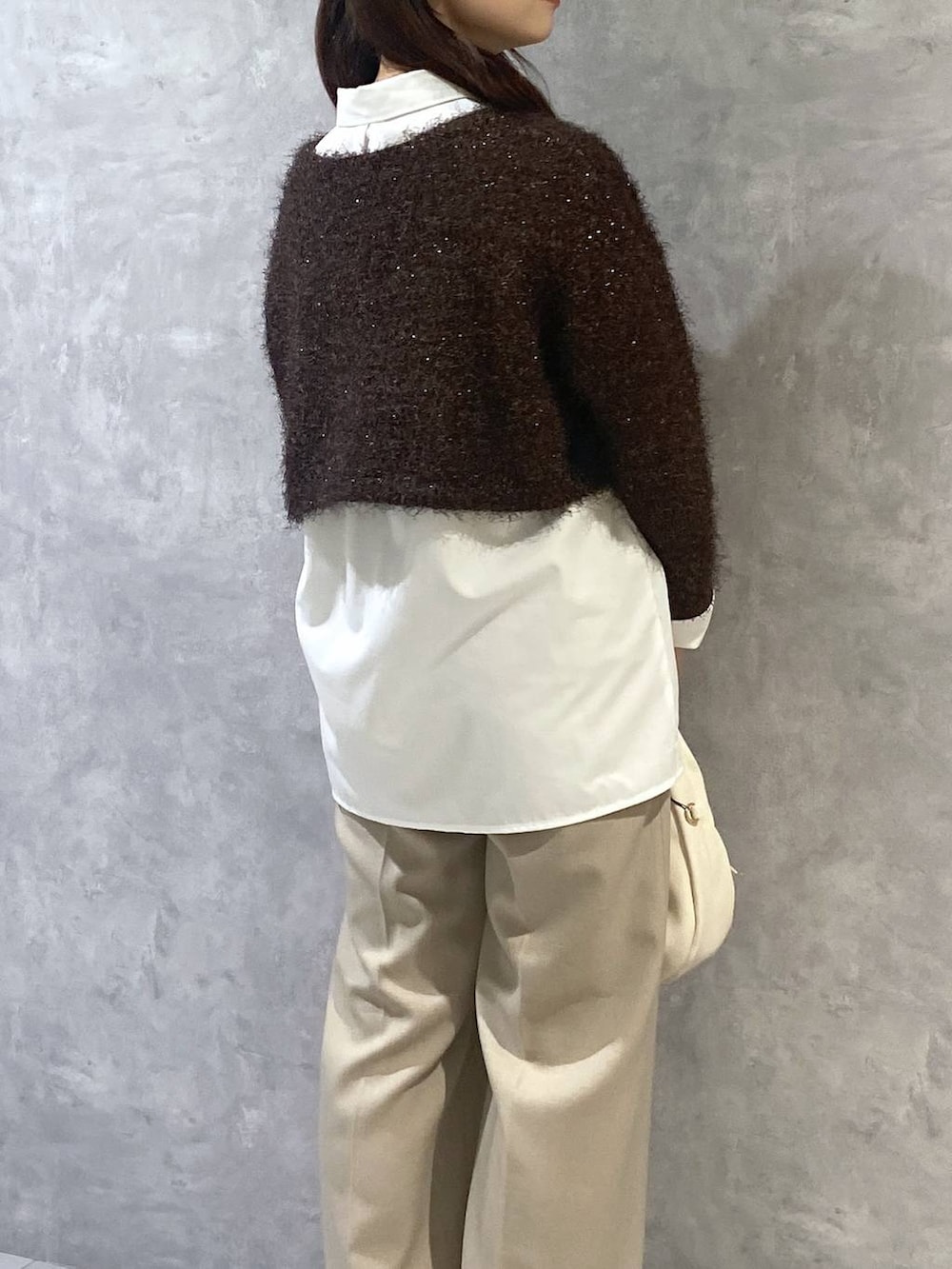 ホワイト系のシャツ/ブラウス、ホワイト系のハンドバッグ、ベージュ系のスラックスを着用したレディースの秋コーディネートの5枚目の写真