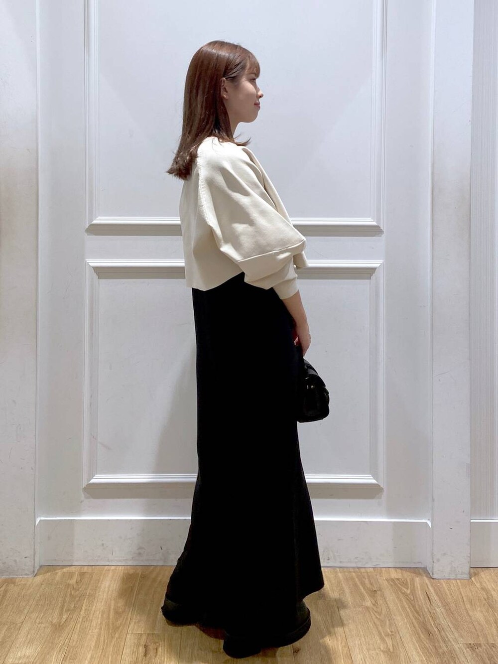 ホワイト系のワンピース、ブラック系のショルダーバッグ、ブラック系のブーツを着用したレディースの秋コーディネートの3枚目の写真