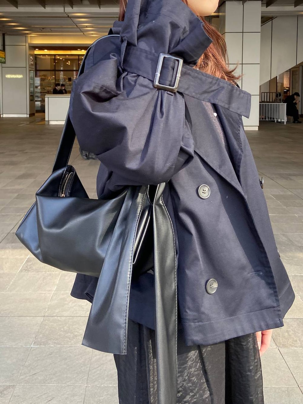 ブラック系のショルダーバッグ、ブルー系のトレンチコート、グレー系のカーディガン/ボレロを着用したレディースの春コーディネートの4枚目の写真