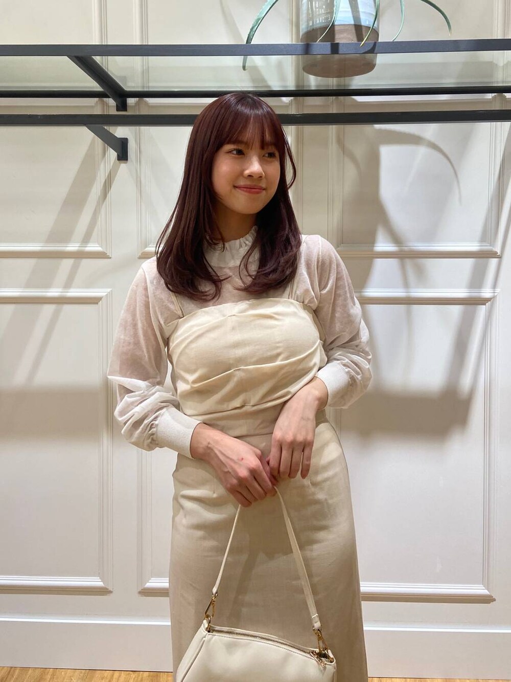 ホワイト系のニット/セーター、ホワイト系のショルダーバッグ、シルバー系のパンプスを着用したレディースの春コーディネートの2枚目の写真