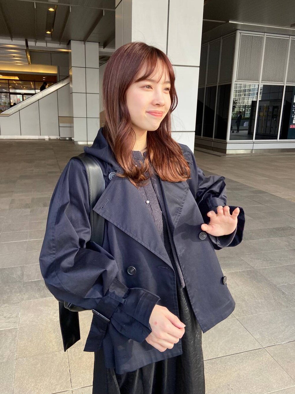 ブラック系のショルダーバッグ、ブルー系のトレンチコート、グレー系のカーディガン/ボレロを着用したレディースの春コーディネートの3枚目の写真