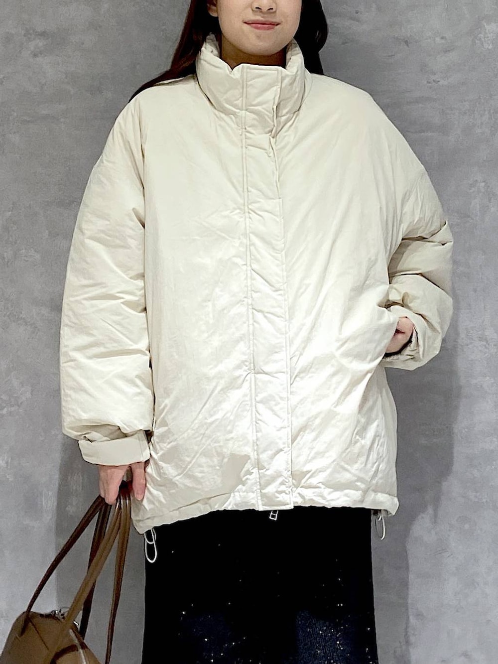 ホワイト系のダウンジャケット/コート、グレー系のスカート、ブラック系のブーツを着用したレディースの冬コーディネートの7枚目の写真