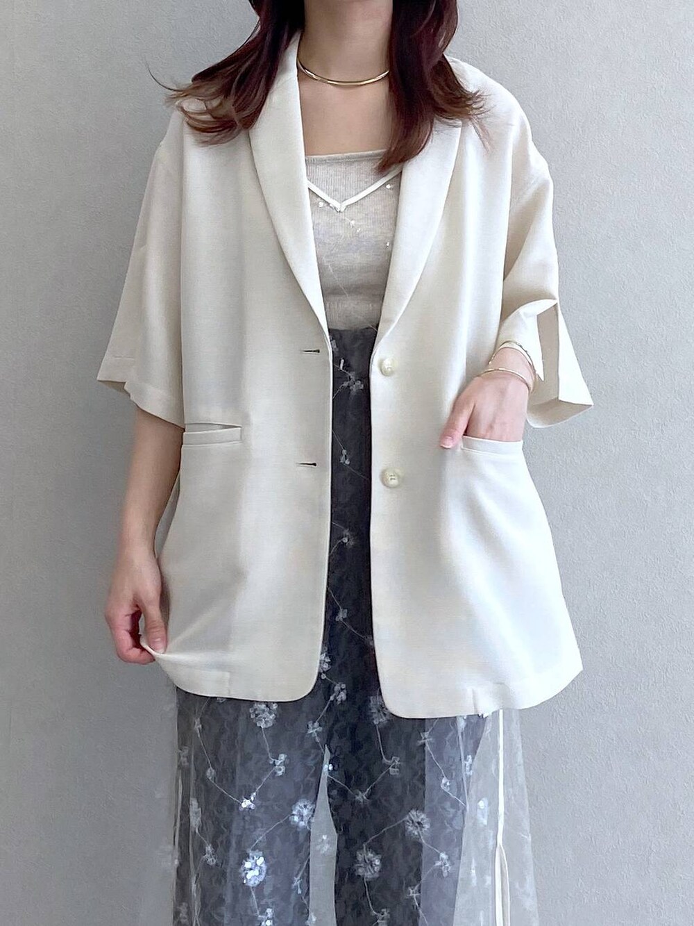 ホワイト系のサンダル、ベージュ系のキャミソール、ホワイト系のテーラードジャケットを着用したレディースの春コーディネートの7枚目の写真