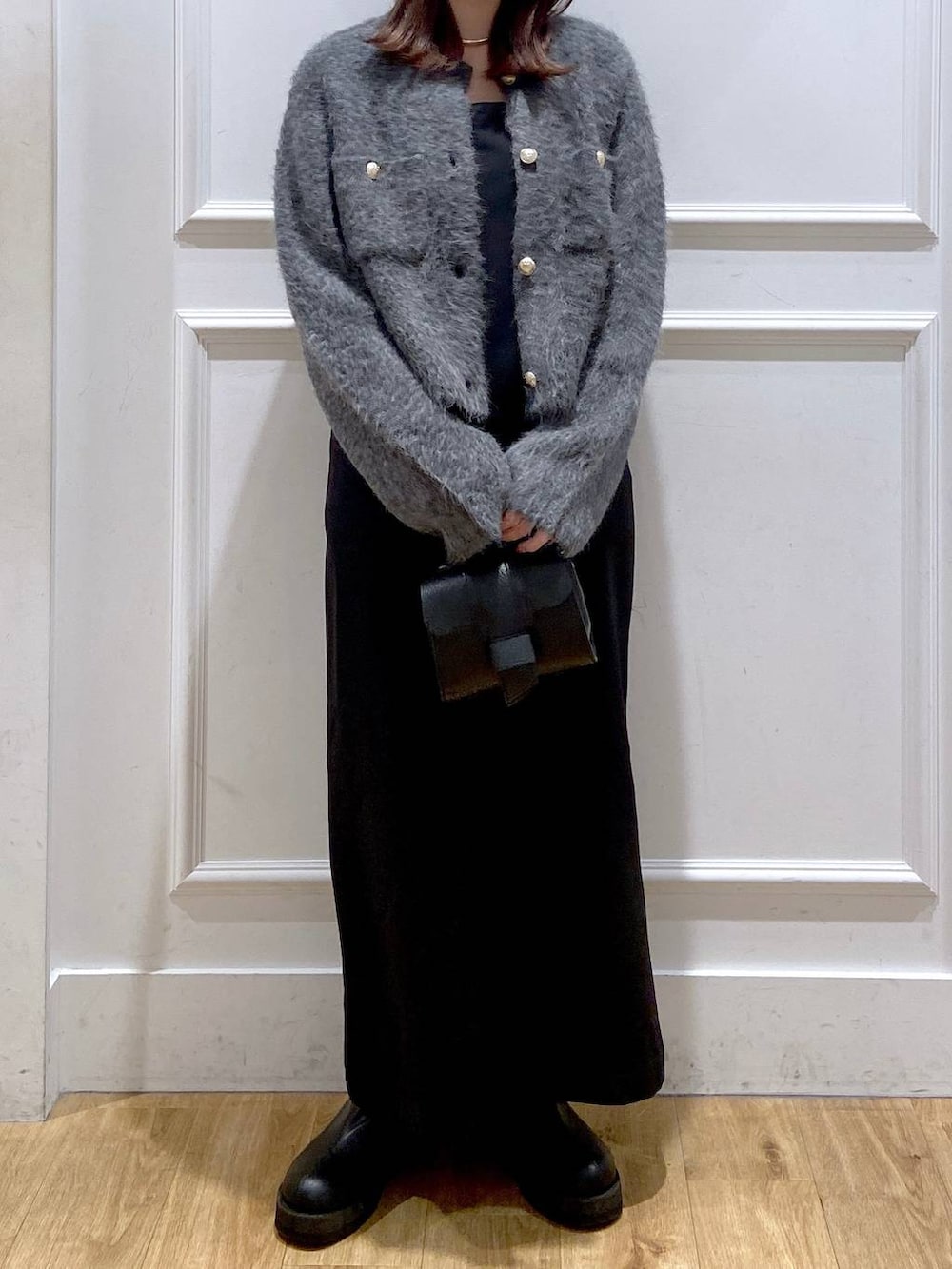 グレー系のカーディガン/ボレロ、ホワイト系のワンピース、ブラック系のショルダーバッグを着用したレディースの冬コーディネートの7枚目の写真