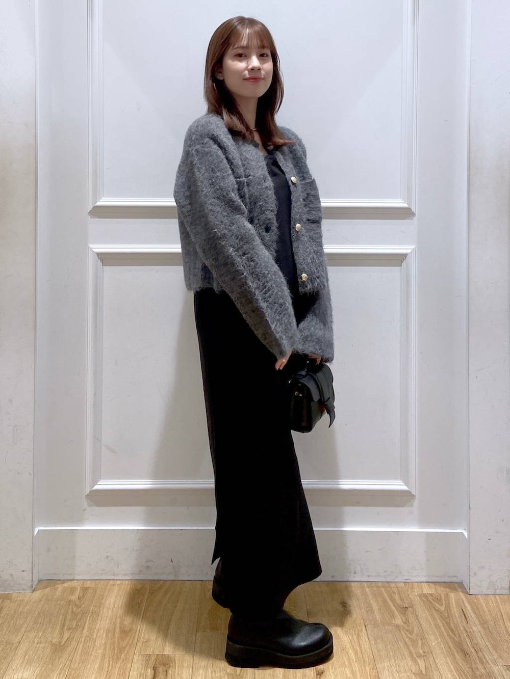 グレー系のカーディガン/ボレロ、ホワイト系のワンピース、ブラック系のショルダーバッグを着用したレディースの冬コーディネートの4枚目の写真