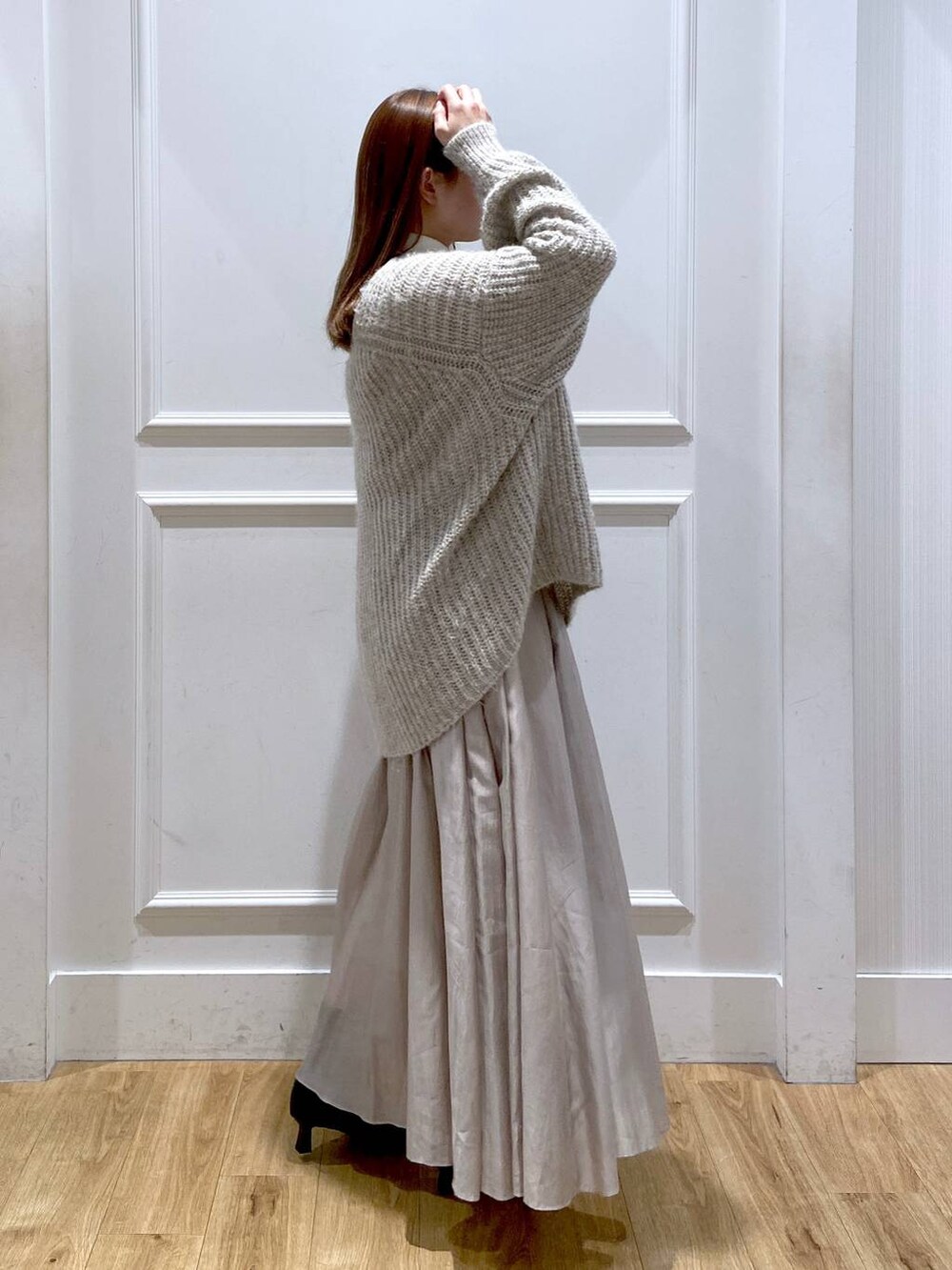 ホワイト系のショルダーバッグ、ベージュ系のスカート、ブラック系のブーツを着用したレディースの冬コーディネートの2枚目の写真