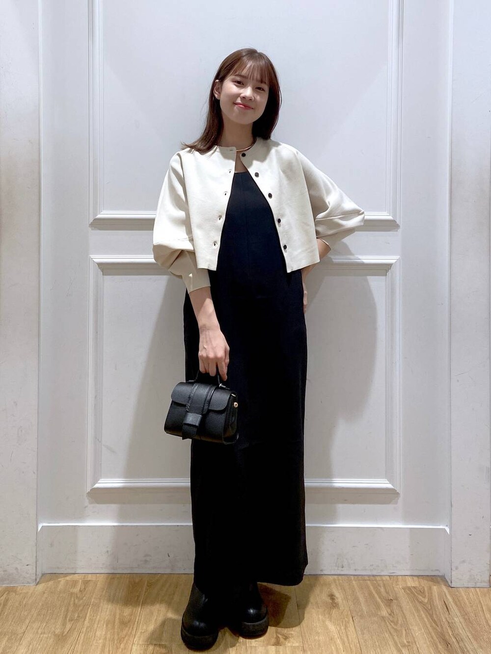 ホワイト系のワンピース、ブラック系のショルダーバッグ、ブラック系のブーツを着用したレディースの秋コーディネートの6枚目の写真