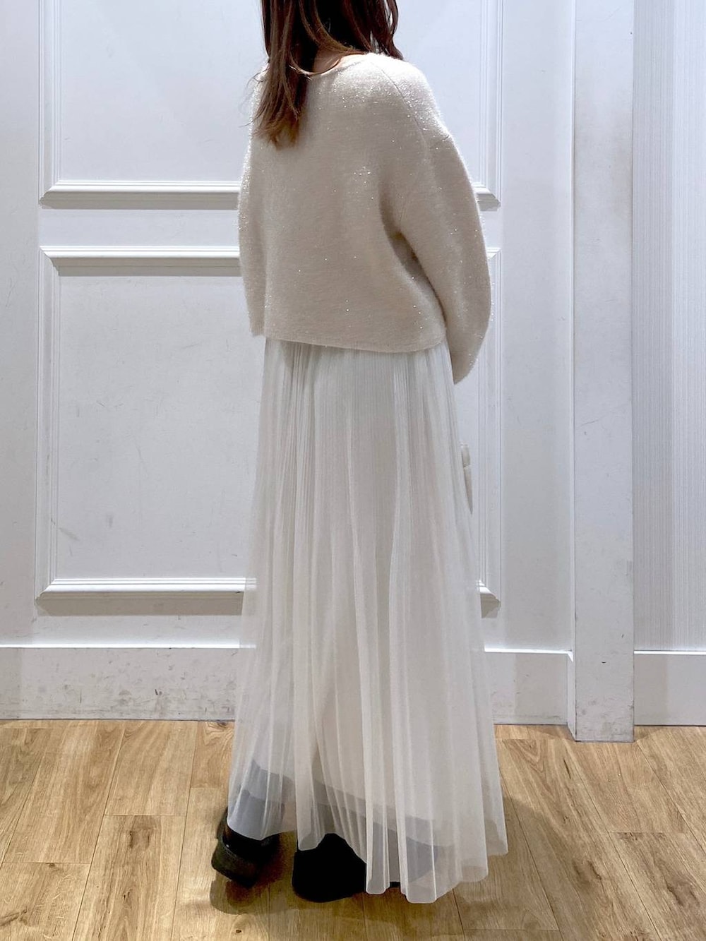 ホワイト系のスカート、ホワイト系のニット/セーター、ブラック系のブーツを着用したレディースの春コーディネートの6枚目の写真