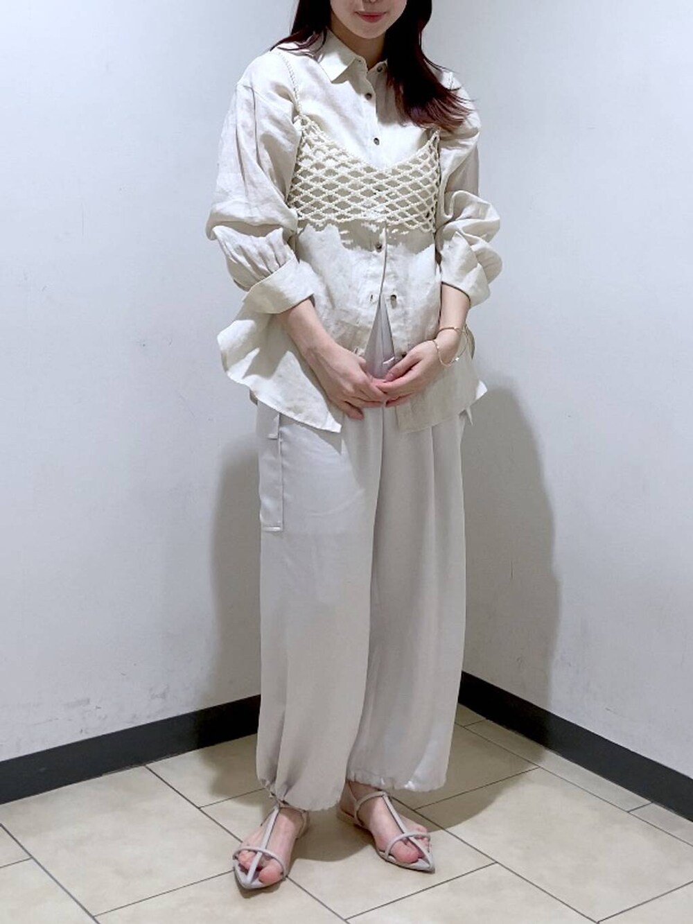 ベージュ系のシャツ/ブラウス、ホワイト系のベスト、ホワイト系のサンダルを着用したレディースの夏コーディネートの3枚目の写真