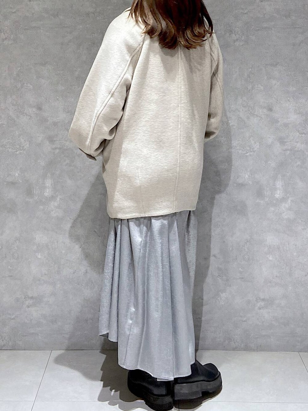 ベージュ系のピーコート、ホワイト系のTシャツ/カットソー、ブラック系のブーツを着用したレディースの冬コーディネートの5枚目の写真