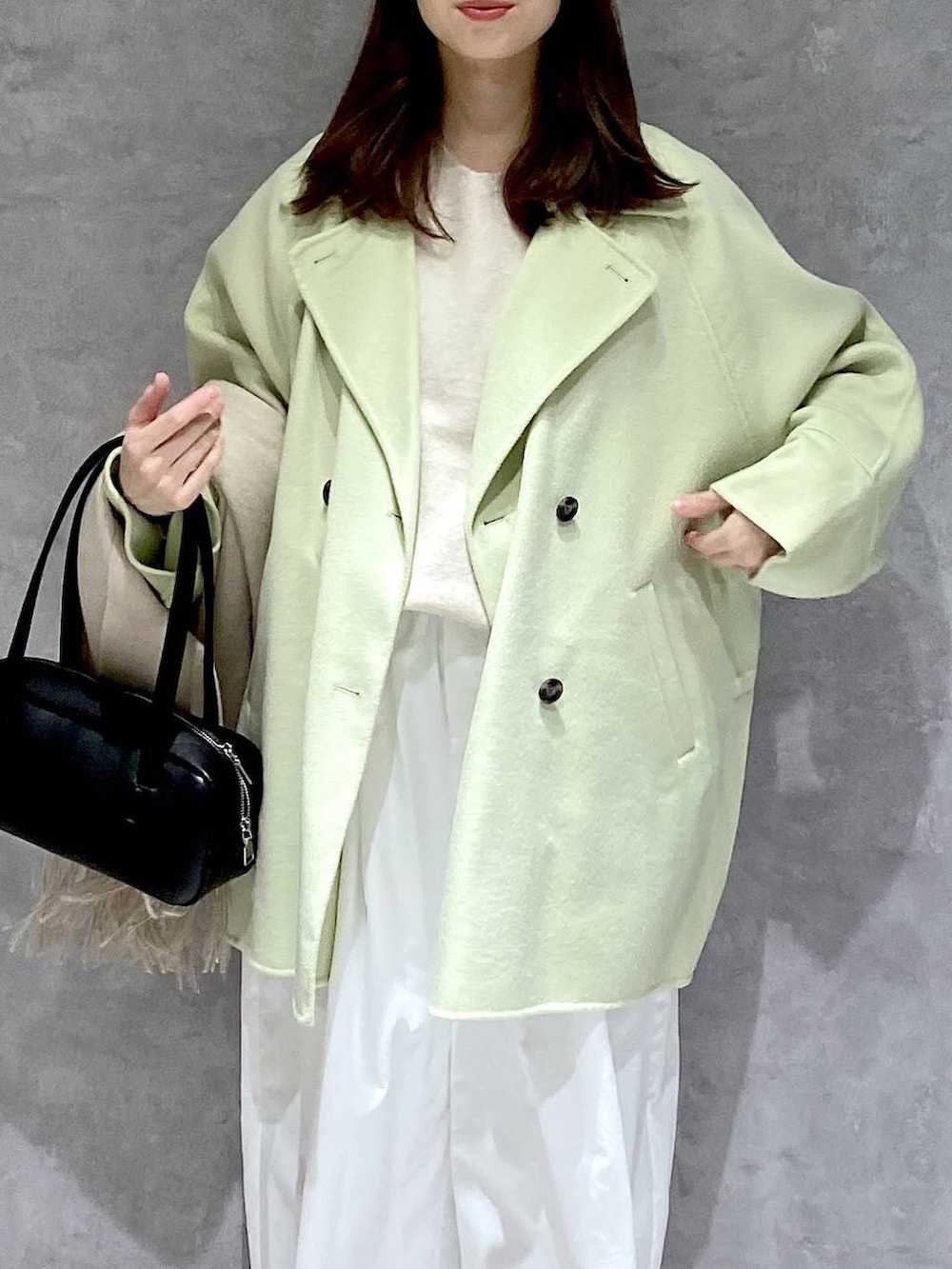 グリーン系のその他アウター、ホワイト系のニット/セーター、ブラック系のブーツを着用したレディースの冬コーディネートの6枚目の写真