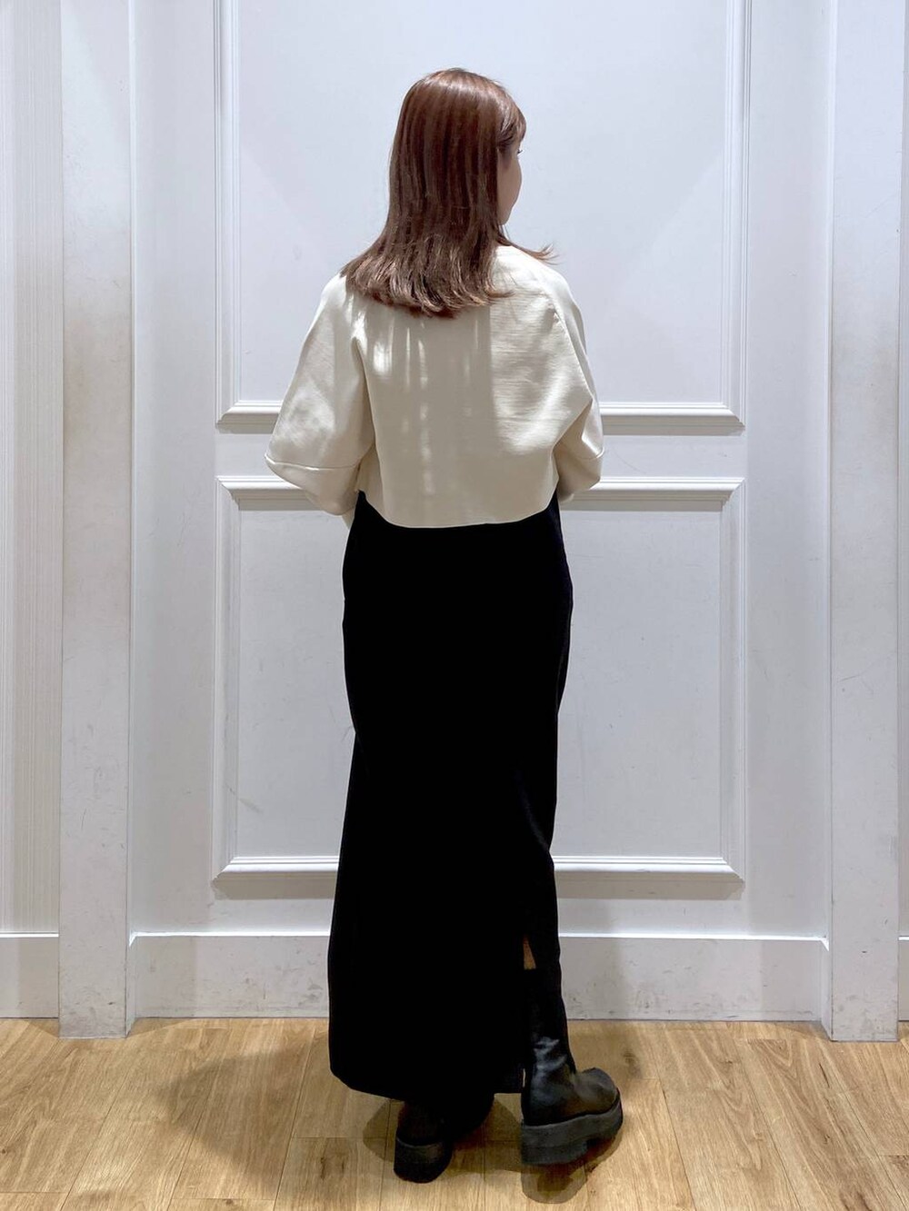 ホワイト系のワンピース、ブラック系のショルダーバッグ、ブラック系のブーツを着用したレディースの秋コーディネートの5枚目の写真