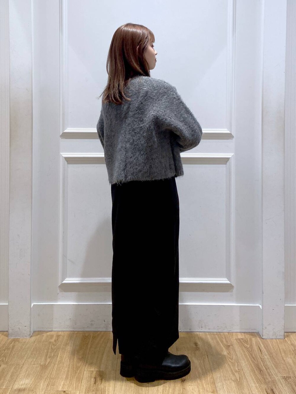 グレー系のカーディガン/ボレロ、ホワイト系のワンピース、ブラック系のショルダーバッグを着用したレディースの冬コーディネートの6枚目の写真