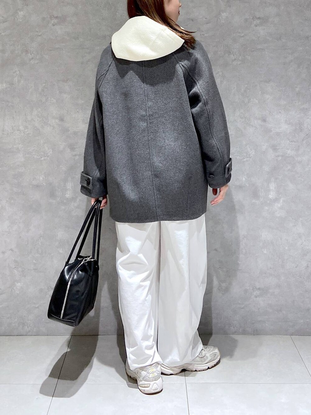 グレー系のピーコート、ホワイト系のその他パンツ、ブラック系のボストンバッグを着用したレディースの秋コーディネートの5枚目の写真