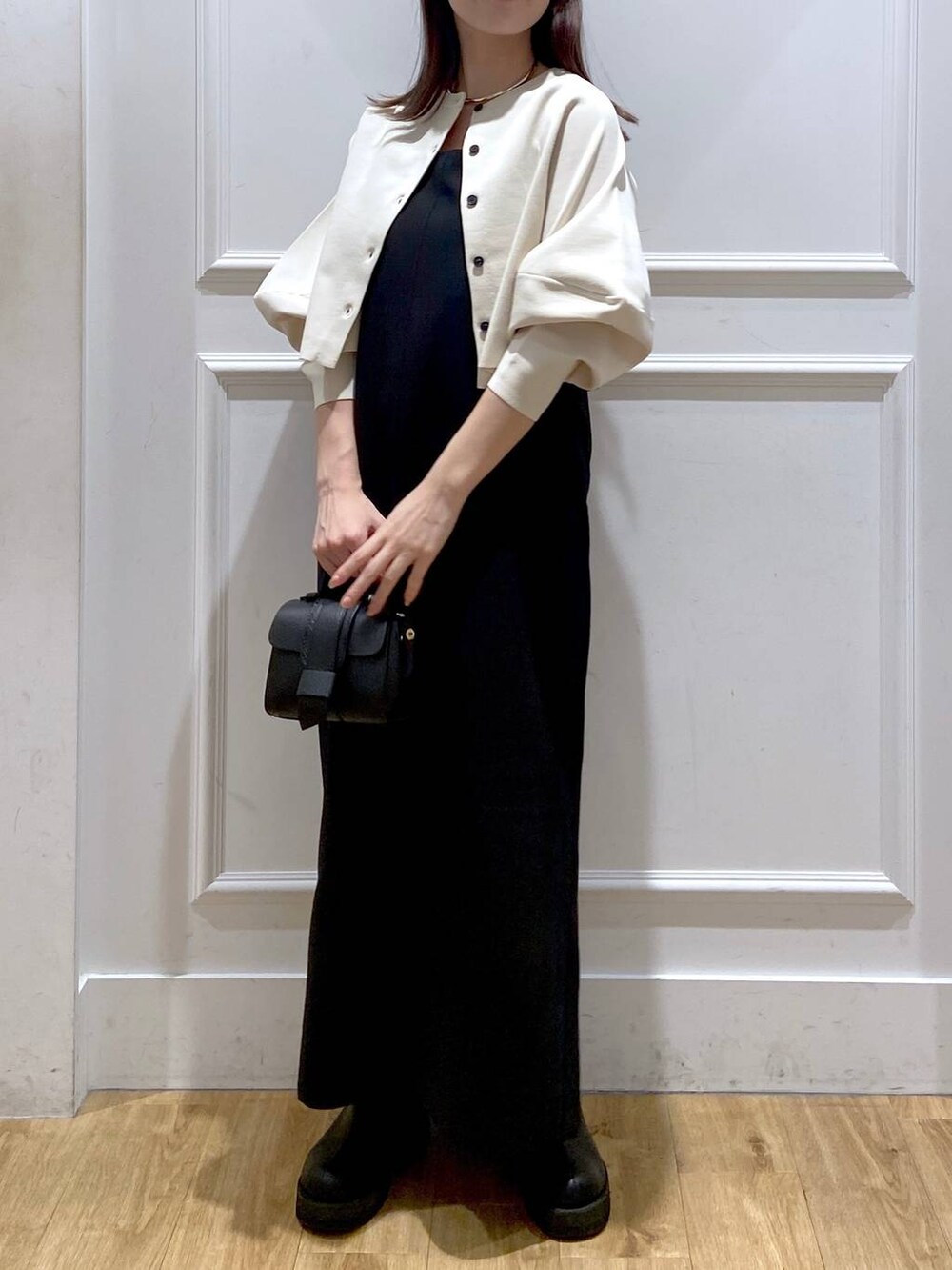 ホワイト系のワンピース、ブラック系のショルダーバッグ、ブラック系のブーツを着用したレディースの秋コーディネートの7枚目の写真