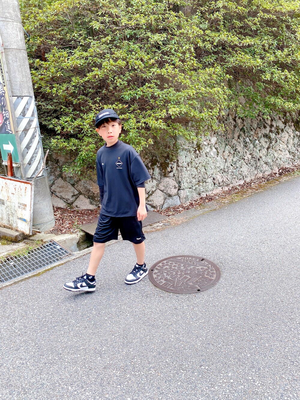 ブラック系のTシャツ/カットソー、ブラック系のスニーカー、ブラック系のキャップを着用したキッズの春コーディネートの3枚目の写真