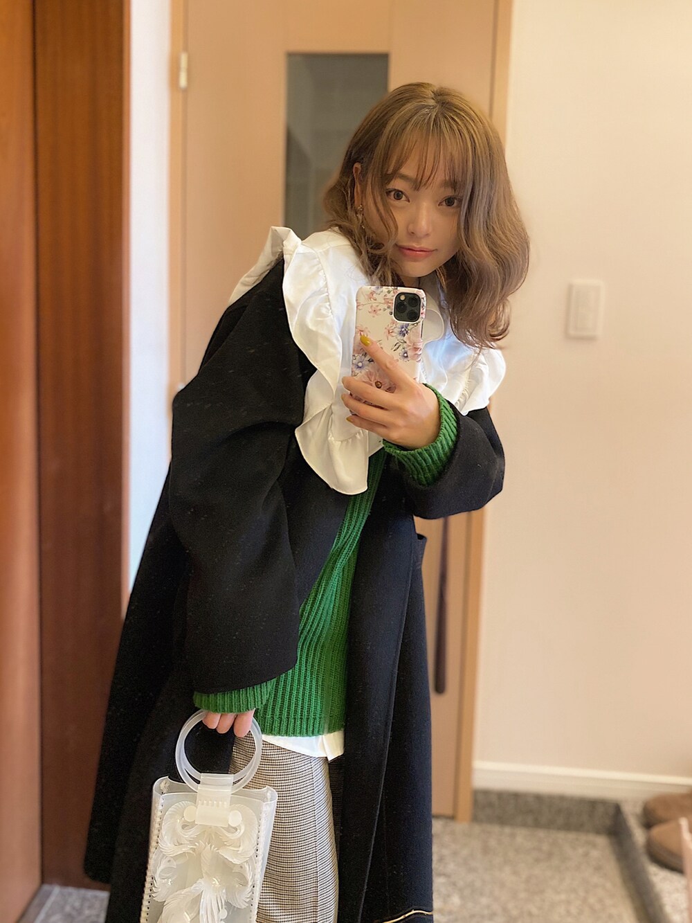 ブラック系のジャケット/アウター、ホワイト系のシャツ/ブラウス、グリーン系のニット/セーターを着用したレディースの冬コーディネートの3枚目の写真