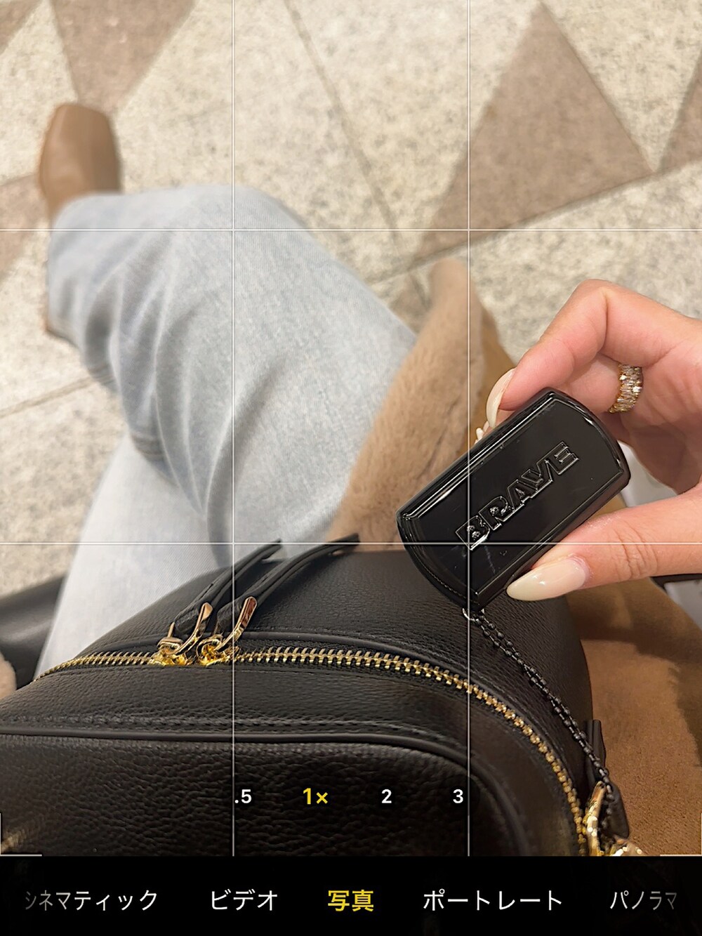 ブラウン系のジャケット/アウター、ブラック系のショルダーバッグ、ブルー系のデニムパンツを着用したレディースの冬コーディネートの3枚目の写真