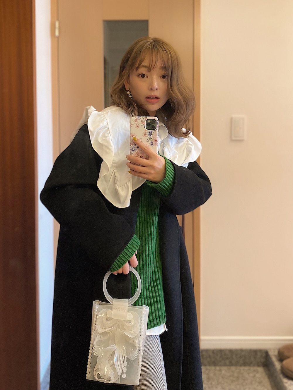 ブラック系のジャケット/アウター、ホワイト系のシャツ/ブラウス、グリーン系のニット/セーターを着用したレディースの冬コーディネートの2枚目の写真