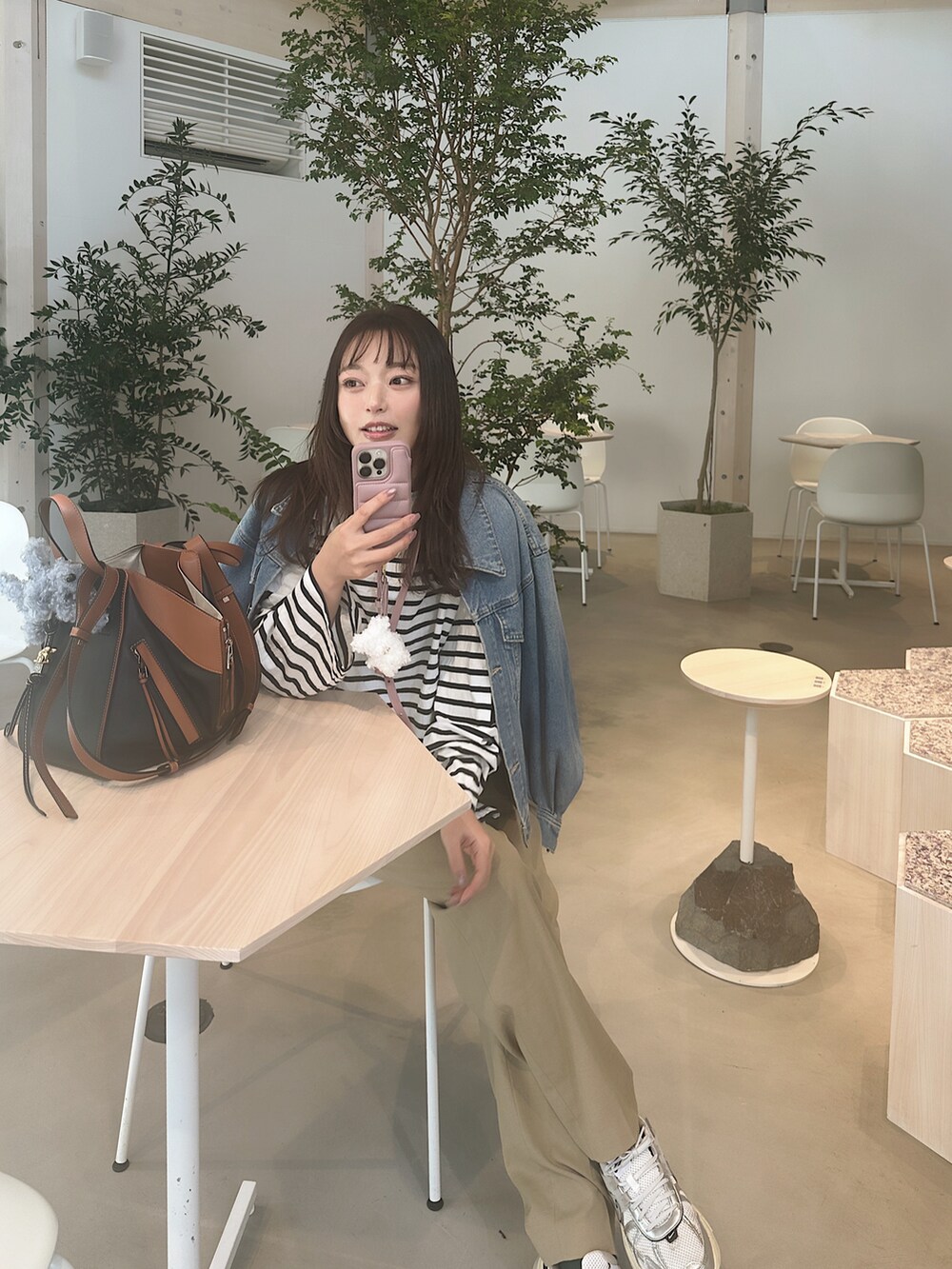 ベージュ系のその他パンツ、ホワイト系のスニーカー、ブルー系のデニムジャケットを着用したレディースの春コーディネートの2枚目の写真