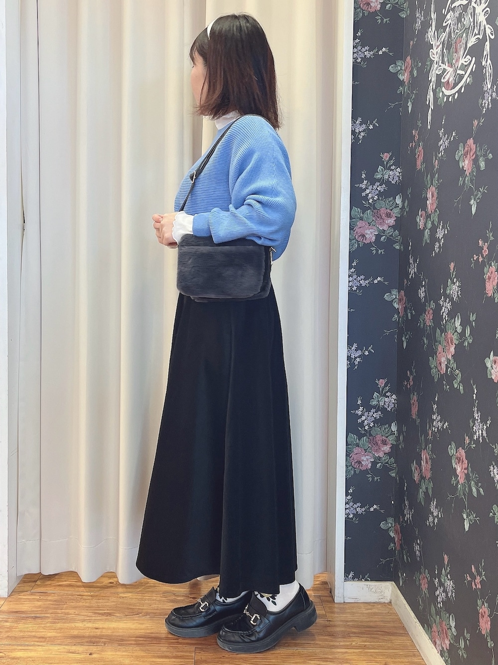 ブラック系のスカート、ブルー系のニット/セーターを着用したレディースの冬コーディネートの2枚目の写真