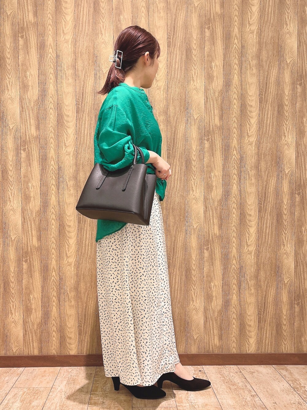 グリーン系のシャツ/ブラウス、ベージュ系のスカート、ブラック系のトートバッグを着用したレディースの春コーディネートの2枚目の写真