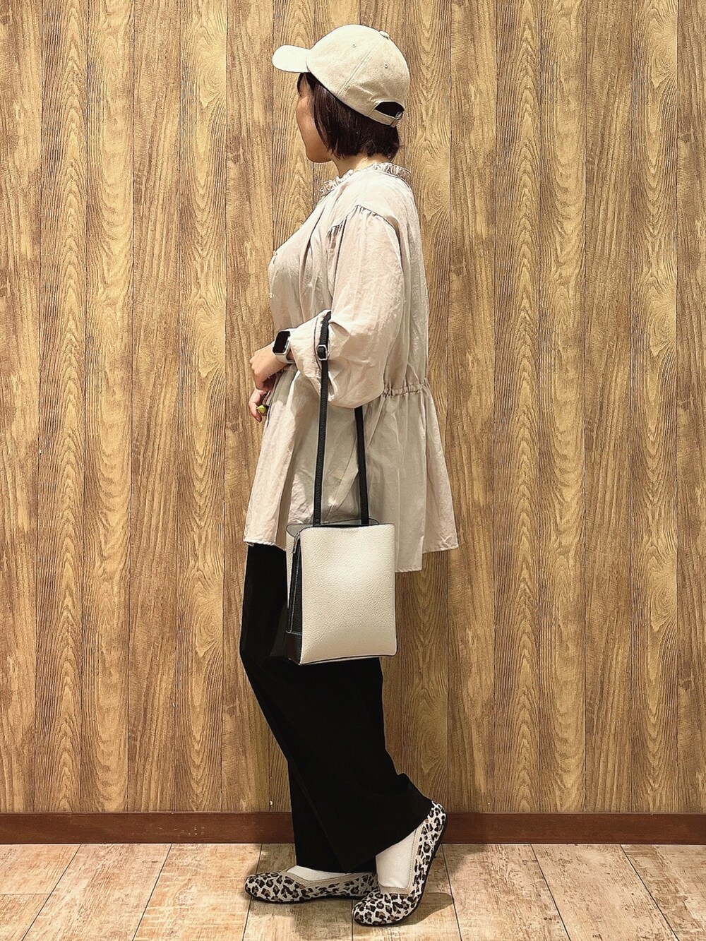ベージュ系のシャツ/ブラウス、イエロー系のパンプス、ブラック系のショルダーバッグを着用したレディースの秋コーディネートの2枚目の写真
