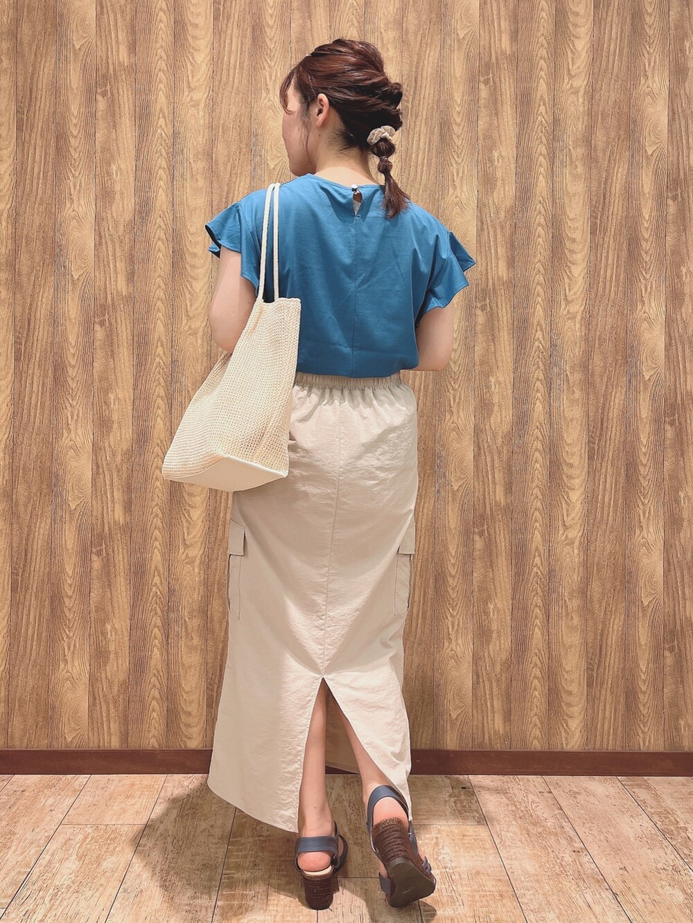 ブルー系のTシャツ/カットソー、ベージュ系のスカート、ホワイト系のトートバッグを着用したレディースの春コーディネートの3枚目の写真